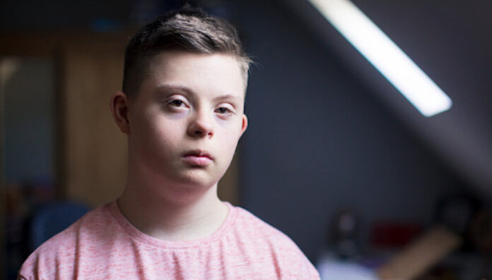 A boy with down syndrome poses for a headshot. The underserved cohort needing better medicine safety and clinical care