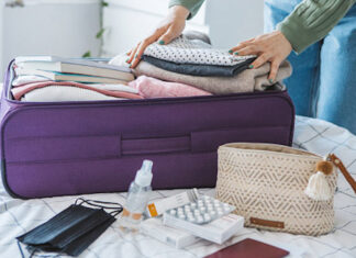 Travel health pharmacists Packing a suitcase with travel essentials, supported by travel health pharmacists
