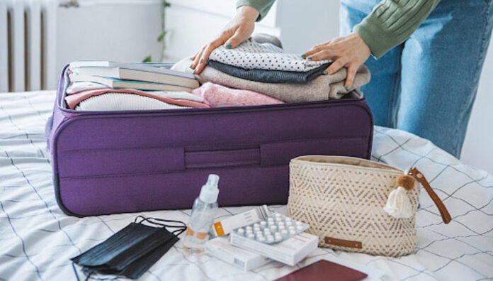 gettyimages-1385184395-170667a Packing a suitcase with travel essentials, supported by travel health pharmacists