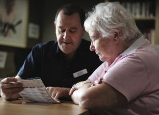 Positive Intervention Pharmacist providing positive intervention in aged care by reviewing medications with elderly patient