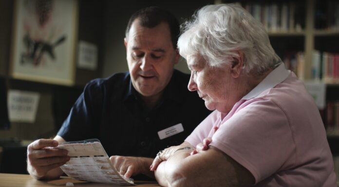 Positive Intervention Pharmacist providing positive intervention in aged care by reviewing medications with elderly patient