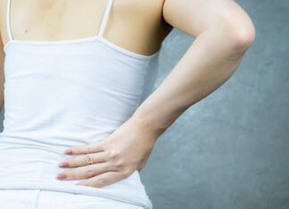 Empagliflozin for reducing risk of kidney stones A woman holding her lower back in discomfort, illustrating pain associated with kidney stones