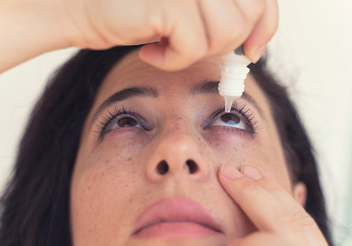 Applying eye drops for eye care