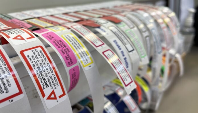 IMG_6312 Caution labels in pharmacy arranged on a dispenser roll