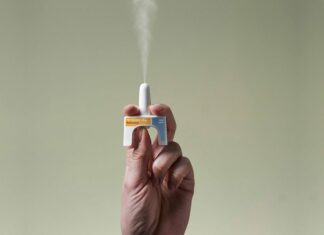 Take-home naloxone: How to ensure you save a life Hand holding a naloxone nasal spray device releasing medication
