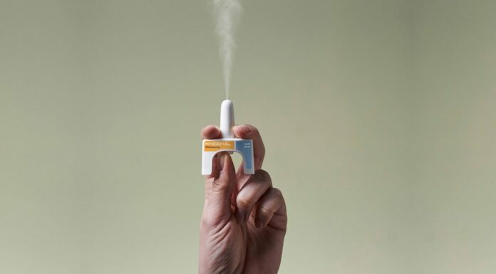 Take-home naloxone: How to ensure you save a life Hand holding a naloxone nasal spray device releasing medication