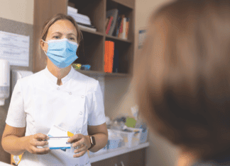 New doors opening Pharmacist wearing a mask consulting with a patient, demonstrating pharmacists practising to full scope of care