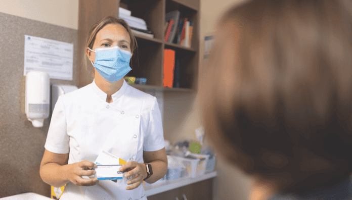 PIC_4114 Pharmacist wearing a mask consulting with a patient, demonstrating pharmacists practising to full scope of care