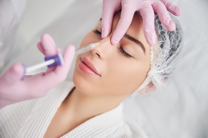 Calm female patient undergoing injectable beauty procedure Calm female patient undergoing injectable beauty procedure
