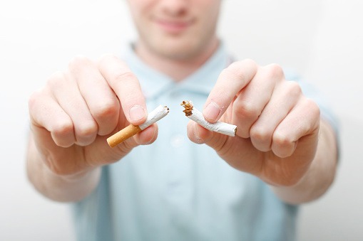 Man breaking a cigarette to quit smoking