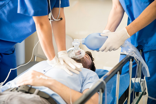 Medical team providing emergency breathing support to a patient in hospital