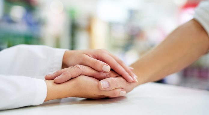 pharmacist holding patient hand