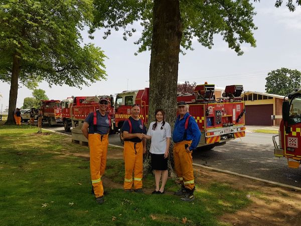 Helen Feng, owner of the Alliance Pharmacy in Tallangatta, VIC, with members of the local Country Fire Authority crew. Photo: supplied.