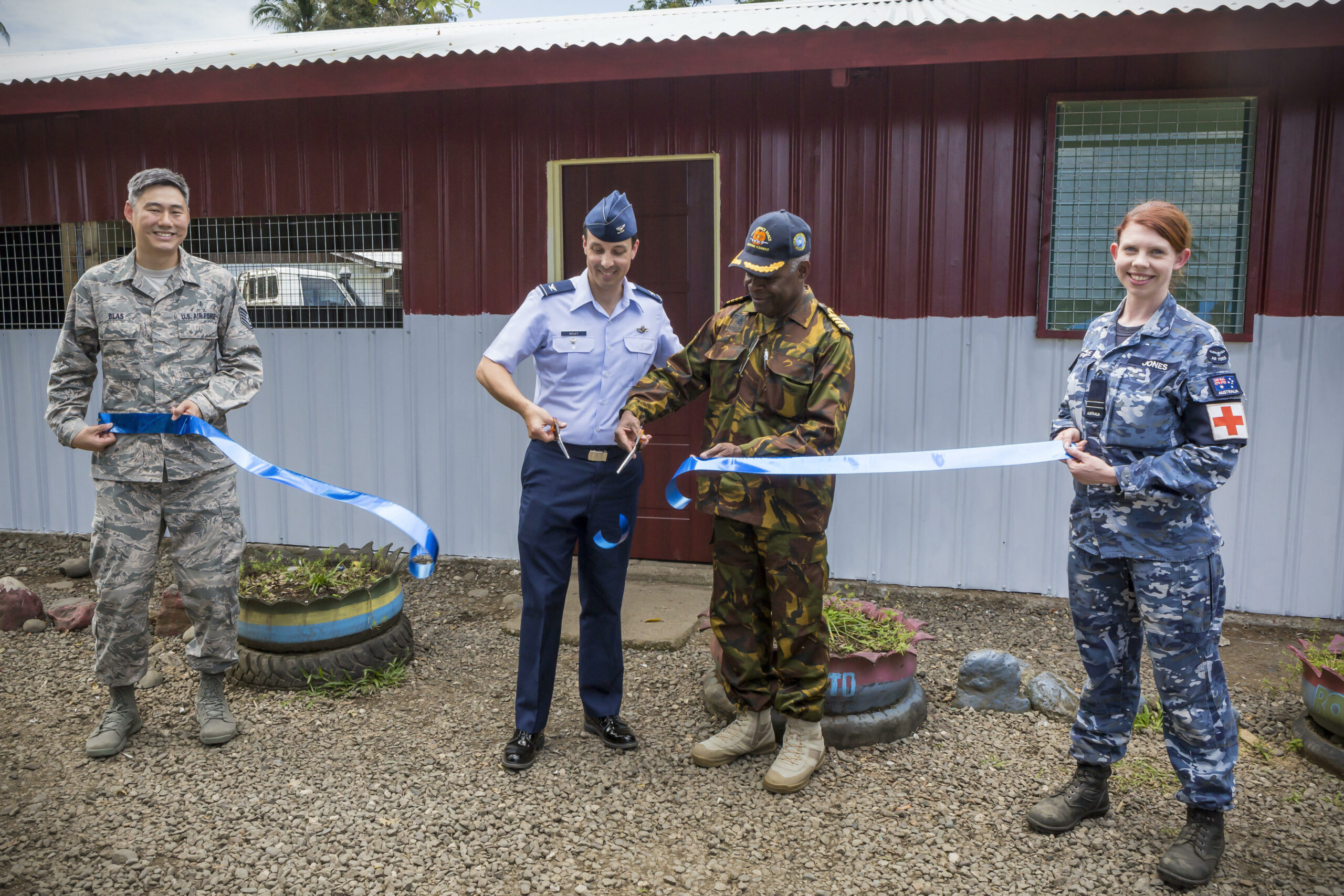 FLTLT Jones (far right) with United States Pacific Air Forces Colonel Darryl Insley and Papua New Guinea Defence Force Chief of Staff Captain Philip Polewara in September 2019 at the opening of a new classroom at Bowali Primary School in Lae, Papua New Guinea. The building had been used as a makeshift pharmacy the previous week as part of Exercise Pacific Angel.