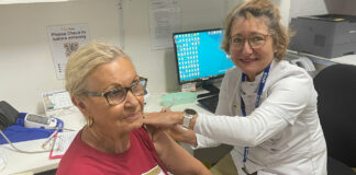 Pharmacist Sarah Parry-Okeden vaccinating a patient at Acton Health Pharmacy