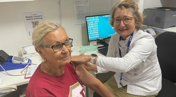 Pharmacist Sarah Parry-Okeden vaccinating a patient at Acton Health Pharmacy
