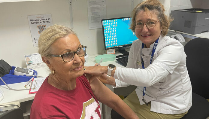 Pharmacist Sarah Parry-Okeden vaccinating a patient at Acton Health Pharmacy