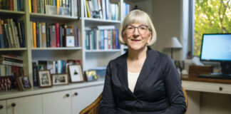 Photo of Sarah Gillespie MPS sitting down inside her library