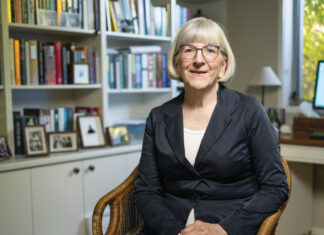 Photo of Sarah Gillespie MPS sitting down inside her library