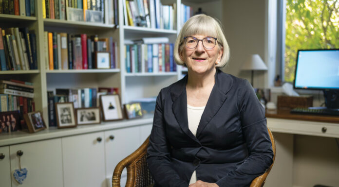 Photo of Sarah Gillespie MPS sitting down inside her library