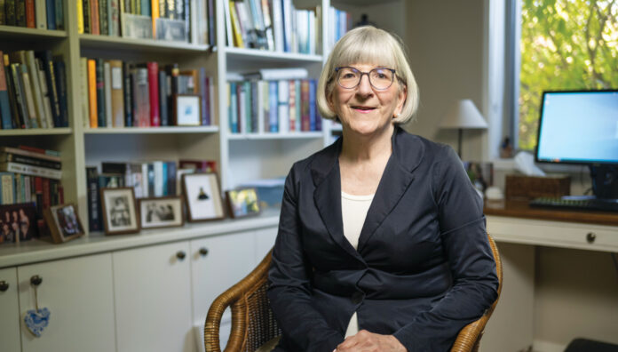 Photo of Sarah Gillespie MPS sitting down inside her library