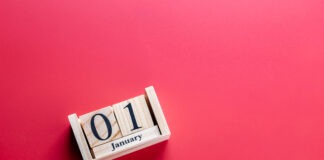 Key changes coming for pharmacists in 2026 Wooden block calendar with January 01 on red surface, horizontal shot. Clean photo symbolizing New Year and celebration. Concept of new year celebration