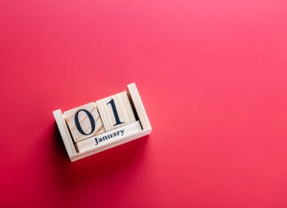 Key changes coming for pharmacists in 2026 Wooden block calendar with January 01 on red surface, horizontal shot. Clean photo symbolizing New Year and celebration. Concept of new year celebration