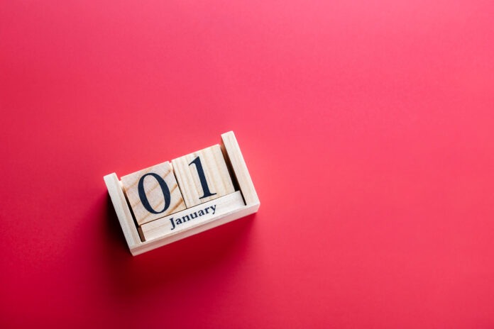 Wooden block calendar with January 01 on red surface, horizontal shot. Clean photo symbolizing New Year and celebration. Concept of new year celebration Wooden block calendar with January 01 on red surface, horizontal shot. Clean photo symbolizing New Year and celebration. Concept of new year celebration